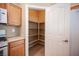 Well-organized pantry with ample shelving provides convenient storage next to wooden cabinets and tile flooring at 10643 Petricola St # 103, Las Vegas, NV 89183