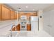 Well-lit kitchen featuring tile countertops, white appliances, and wooden cabinetry at 10730 Amber Ridge Dr # 205, Las Vegas, NV 89144