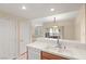 Bright kitchen with pass-through to the living area, featuring tiled counters and a double sink at 10730 Amber Ridge Dr # 205, Las Vegas, NV 89144
