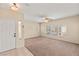 Bright living room with neutral carpet, ceiling fan, and large windows at 10730 Amber Ridge Dr # 205, Las Vegas, NV 89144