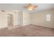 Spacious living room with neutral carpet, ceiling fan, and adjacent tiled entry at 10730 Amber Ridge Dr # 205, Las Vegas, NV 89144