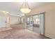 Open living area featuring neutral carpet, patio access, and a contemporary light fixture at 10730 Amber Ridge Dr # 205, Las Vegas, NV 89144