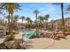 Resort-style community pool area featuring lush landscaping, mature palms, and inviting lounge spaces at 10730 Amber Ridge Dr # 205, Las Vegas, NV 89144
