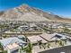 Overhead shot of a residential area nestled against a striking mountain backdrop under a clear sky at 11185 Black Fire Opal Dr, Las Vegas, NV 89138