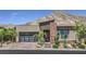 Modern home featuring beautiful desert landscaping, a glass garage door and striking mountain views at 11185 Black Fire Opal Dr, Las Vegas, NV 89138