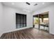 Versatile room featuring modern light fixture, wood-look floors, and sliding doors leading to an outdoor area at 11185 Black Fire Opal Dr, Las Vegas, NV 89138