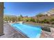 Inviting backyard pool features lush landscaping, fire pit and mountain views at 11185 Black Fire Opal Dr, Las Vegas, NV 89138