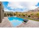 A backyard featuring a luxurious pool, landscaping and outdoor seating with a fire feature at 11185 Black Fire Opal Dr, Las Vegas, NV 89138