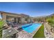 Relaxing backyard pool surrounded by brick patio, lush landscaping, and stylish outdoor seating at 11185 Black Fire Opal Dr, Las Vegas, NV 89138