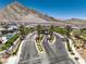 Scenic street view showcasing lush landscaping, palm trees, and mountain views in a vibrant community at 11185 Black Fire Opal Dr, Las Vegas, NV 89138
