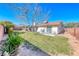 Spacious backyard with a covered patio, lawn, and tasteful landscaping, offering a perfect outdoor retreat at 1120 Mariposa Way, Boulder City, NV 89005