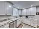 Close-up of the kitchen area featuring a stainless steel dishwasher, sink, and custom white cabinetry at 1120 Mariposa Way, Boulder City, NV 89005