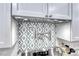 Close-up of a pot filler faucet over range with decorative backsplash and light gray cabinets at 1120 Mariposa Way, Boulder City, NV 89005