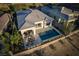 Aerial view of an elegant home featuring a backyard pool, covered patio with dining area, and well-kept landscaping at 13 Porto Malaga St, Henderson, NV 89011