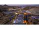 Aerial view showcasing luxurious homes along a street with lake and city lights in the distance at 13 Porto Malaga St, Henderson, NV 89011