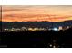Expansive city skyline view with colorful buildings and mountain silhouette against a vibrant orange and pink sunset at 13 Porto Malaga St, Henderson, NV 89011
