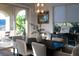 Bright dining room featuring a dark wood table, chandelier, and sliding glass doors to the outdoor patio at 13 Porto Malaga St, Henderson, NV 89011