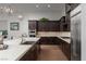Modern kitchen featuring a large island with seating, custom cabinetry, stainless steel appliances, and hardwood floors at 13 Porto Malaga St, Henderson, NV 89011