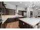 Gourmet kitchen featuring dark wood cabinetry, stainless steel appliances, an island, and hardwood floors at 13 Porto Malaga St, Henderson, NV 89011