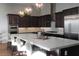 Modern kitchen featuring a large quartz island, dark wood cabinets and stainless steel appliances at 13 Porto Malaga St, Henderson, NV 89011