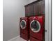 Laundry room featuring red front load washer and dryer and upper cabinets at 13 Porto Malaga St, Henderson, NV 89011