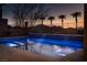 Inviting swimming pool with cascading water feature, lit up with blue lights, creating a relaxing oasis at 13 Porto Malaga St, Henderson, NV 89011