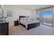 Serene bedroom featuring a queen-sized bed, carpet, and sliding glass doors to a private balcony at 180 Native Stone St, Las Vegas, NV 89138