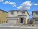 Charming two-story home showcasing a brick-accented facade, well-manicured landscaping, and an attached garage at 180 Native Stone St, Las Vegas, NV 89138