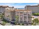 Multi-story condominium building featuring covered parking and a tennis court in the background at 205 E Harmon Ave # 212, Las Vegas, NV 89169