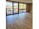 Bright living room features wood-look flooring, sliding doors and balcony access overlooking city views at 205 E Harmon Ave # 212, Las Vegas, NV 89169