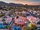 Neighborhood aerial showcasing many red roofs, palm trees and manicured lawns with the sunset and mountains in the distance at 2232 Barchetta Dr, Las Vegas, NV 89134