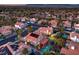 Expansive aerial shot displays a neighborhood featuring homes with swimming pools, solar panels, and a distant mountain range at 2232 Barchetta Dr, Las Vegas, NV 89134