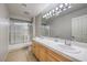 Bright bathroom featuring tile floors and a double sink vanity with framed mirror at 2232 Barchetta Dr, Las Vegas, NV 89134