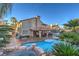 Expansive backyard with pool, covered patio, built-in BBQ, and lush greenery at 2232 Barchetta Dr, Las Vegas, NV 89134