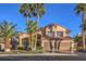 Two-story home featuring a three car garage, mature palm trees and well manicured landscaping at 2232 Barchetta Dr, Las Vegas, NV 89134