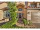 Home exterior with a large front door, well-maintained landscaping, and a two-car garage at 2232 Barchetta Dr, Las Vegas, NV 89134
