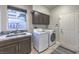 Bright laundry room with front-load washer/dryer, ample cabinets, and tile backsplash at 2232 Barchetta Dr, Las Vegas, NV 89134