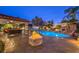 Spacious patio with built-in firepit, grill, pool, seating, and lighting at 2232 Barchetta Dr, Las Vegas, NV 89134