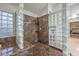 Modern shower featuring marble walls, glass block partition, and dual shower heads at 2232 Barchetta Dr, Las Vegas, NV 89134
