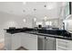 Contemporary kitchen featuring white cabinetry, black countertops, stainless steel appliances and modern pendant lighting at 2700 Las Vegas Blvd # 1301, Las Vegas, NV 89109