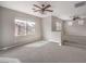 Spacious bonus room with neutral walls, carpeted floors, and ceiling fans features many windows at 3725 Moonshine Falls Ave, North Las Vegas, NV 89085