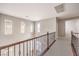 Hallway features neutral walls, carpeted floors, and wood and wrought iron railing overlooking the home's entrance at 3725 Moonshine Falls Ave, North Las Vegas, NV 89085