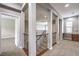 Hallway with neutral walls, carpeted floors, and desk area has a wood and wrought iron staircase railing at 3725 Moonshine Falls Ave, North Las Vegas, NV 89085