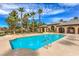 Community pool surrounded by palm trees, lounge chairs and a nearby recreation center at 3725 Moonshine Falls Ave, North Las Vegas, NV 89085