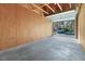 Unfinished garage interior with exposed beams, concrete floor, and overhead door leading to parking area at 3740 Desert Marina Dr # 7, Laughlin, NV 89029