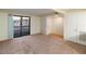 Bright living room with carpet, neutral walls, white trim, access to patio, and a view to kitchen at 3740 Desert Marina Dr # 7, Laughlin, NV 89029