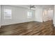 Spacious living room with wood-look flooring, neutral paint, ceiling fan, and large windows with blinds for natural light at 3909 Grazing Gazelle Ave, North Las Vegas, NV 89084