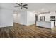 Open-concept living and kitchen area featuring wood-look floors, neutral paint, and modern ceiling fan at 3909 Grazing Gazelle Ave, North Las Vegas, NV 89084