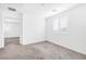 A bright bedroom with soft carpeting, a shuttered window, and a glimpse into the hallway at 4125 Venus Falls Ave, North Las Vegas, NV 89084