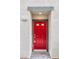The front entrance to the house features a vibrant red door and gray stone tile walkway at 4125 Venus Falls Ave, North Las Vegas, NV 89084
